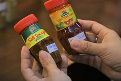 Ví dụ đối với sản phẩm sa tế tôm Thuận Phát, một trong những hình thức làm giả là không có logo in nổi trên nắp, ngày sản xuất-hạn sử dụng bị mờ, xóa một phần; trên bao bì có hình ảnh và chữ viết thiếu sắc nét, bong khỏi sản phẩm... (Ảnh: Minh Anh/Vietnam