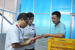 Lực lượng chức năng kiểm tra tại cơ sở sản xuất lạp xưởng. (Ảnh: Lê Thúy Hằng/TTXVN)