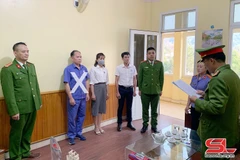 Cơ quan Cảnh sát điều tra đọc quyết định khởi tố đối với đối tượng Trần Tiến Dũng (dấu X). (Nguồn: Báo Sơn La)