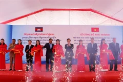 Đại biểu thực hiện nghi thức đưa cửa khẩu quốc tế đường bộ và đường sông Vĩnh Xương vào hoạt động. (Ảnh: Công Mạo/TTXVN)