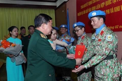 Thượng tướng Hoàng Xuân Chiến trao quyết định cho các sỹ quan. (Ảnh: Trọng Đức/TTXVN)