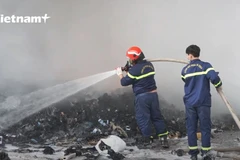 Lực lượng cứu hỏa đag dập tắt đám cháy. (Ảnh: P.V/Vietnam+)