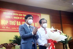 Bí thư Tỉnh ủy, Chủ tịch Hội đồng Nhân dân tỉnh Cà Mau Nguyễn Tiến Hải tặng hoa chúc mừng ông Nguyễn Minh Luân được bầu giữ chức Phó Chủ tịch UBND tỉnh Cà Mau, nhiệm kỳ 2021-2026. (Ảnh: Huỳnh Anh/TTXVN)