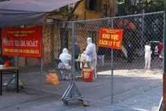 Lực lượng y tế phường Nguyễn Du lấy mẫu xét nghiệm cho người dân phố Đỗ Hành. (Ảnh: Hoàng Hiếu/TTXVN)