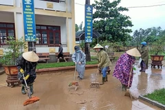 Phụ nữ tham gia dọn dẹp vệ sinh khắc phục hậu quả sau mưa lũ. (Ảnh: Võ Dung/TTXVN)