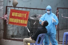 Nhân viên y tế lấy mẫu xét nghiệm COVID-19 cho các trường hợp liên quan đến các ca F0 trên địa bàn phường Văn Miếu. (Ảnh: Minh Quyết/TTXVN)