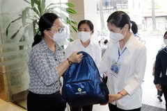 Tình nguyện viên Công giáo nhận balô, vật dụng sinh hoạt thiết yếu trong lễ xuất quân tình nguyện viên tôn giáo tham gia phục vụ tuyến đầu chống dịch COVID-19 hồi tháng 8/2021. (Ảnh: Xuân Khu/TTXVN)