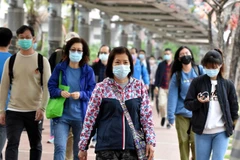 Người dân đeo khẩu trang phòng dịch COVID-19 tại Hong Kong, Trung Quốc. (Ảnh: THX/TTXVN)
