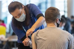 Nhân viên y tế tiêm vaccine phòng COVID-19 cho người dân tại London, Anh. (Ảnh: THX/TTXVN)