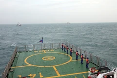 Cảnh sát biển hai nước Việt Nam và Trung Quốc thực hiện nghi thức chào xã giao trên biển. (Ảnh: TTXVN phát)