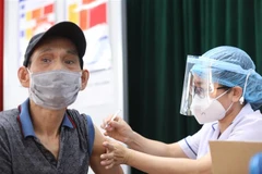 Nhân viên y tế tiêm vaccine phòng COVID-19 cho người dân tại điểm tiêm chủng quận Hai Bà Trưng (Hà Nội). (Ảnh: Minh Quyết/TTXVN)