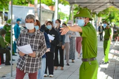 Hướng dẫn người tiêm thực hiện nghiêm việc phòng, chống dịch COVID-19 tại điểm tiêm Trung tâm Văn hóa quận Sơn Trà, Đà Nẵng. (Ảnh: Văn Dũng/TTXVN)