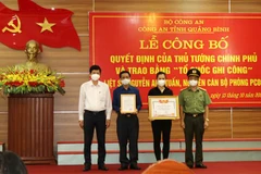 Thừa ủy quyền của Thủ tướng Chính phủ, ông Hồ An Phong - Phó Chủ tịch UBND tỉnh Quảng Bình và Đại tá Nguyễn Tiến Nam, Giám đốc Công an tỉnh đã trao quyết định và Bằng 'Tổ quốc ghi công' cho thân nhân gia đình liệt sỹ Nguyễn Anh Tuấn. (Ảnh: TTXVN phát)
