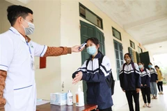Đo thân nhiệt, sát khuẩn tay cho học sinh. (Ảnh minh họa. Nguồn: TTXVN)