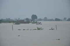 Lực lượng Cảnh sát Phòng cháy chữa cháy và cứu nạn cứu hộ-Công an tỉnh Gia Lai cứu hộ 14 hộ dân đến nơi an toàn. (Ảnh: Quang Thái/TTXVN)