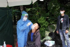 Người dân về Nghệ An thực hiện xét nghiệm nhanh COVID-19 tại chốt kiểm soát COVID-19. (Ảnh: Văn Tý/TTXVN)