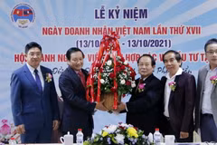 Đại sứ Nguyễn Bá Hùng đang trao lẵng hoa chúc mừng 17 năm ngày Doanh nhân Việt Nam cho ông Dương Đình Bảng, Chủ tịch lâm thời Hội doanh nghiệp Việt Nam hợp tác và đầu tư tại Lào. (Ảnh: Phạm Kiên/Vietnam+)