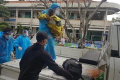 Chị Ái được lực lượng Công an phường Mỹ Thạnh, thành phố Long Xuyên đưa từ khu cách ly tạm thời đến bệnh viên cấp cứu kịp thời. (Ảnh: TTXVN phát)