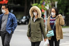 Người dân đã phải mặc áo khoác lông dày khi ra đường. (Ảnh: Thành Đạt/TTXVN)