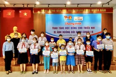 Trao học bổng cho các em học sinh. (Ảnh: Hồng Giang/TTXVN)