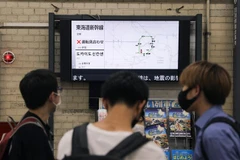 Người dân theo dõi thông tin về lịch trình các chuyến tàu bị hoãn ở nhà ga Tokyo, Nhật Bản do ảnh hưởng của động đất, ngày 7/10/2021. (Ảnh: THX/TTXVN)