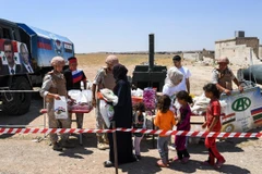 Phát hàng cứu trợ cho người dân Syria ở Abu Duhur, tỉnh Idlib. (Ảnh: AFP/TTXVN)