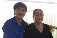 Bà Phạm Thị Hường, phường Ninh Thủy, thị xã Ninh Hòa, tỉnh Khánh Hòa chụp ảnh lưu niệm cùng anh Bùi Hoài Nam, Bí thư Tỉnh đoàn Khánh Hòa khi đến thăm nhân sự kiện 60 năm ngày mở đường Hồ Chí Minh trên biển. (Ảnh: Phan Sáu/TTXVN)