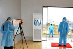 Tiến hành đo thân nhiệt, khai báo y tế đối với cán bộ nhân viên, lái xe, công nhân tại cửa khẩu quốc tế Móng Cái, thành phố Móng Cái. (Ảnh: Bùi Đức Hiếu/TTXVN)