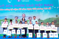 Bà Trương Thị Mai - Ủy viên Bộ Chính trị, Bí thư Trung ương Đảng, Trưởng ban Dân vận Trung ương cùng đại biểu khách mời trao học bổng và sữa của Quỹ Sữa Vươn Cao Việt Nam cho các em học sinh khó khăn có thành tích học tập tốt của trường Tiểu học Tiên Dược