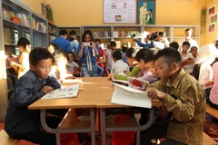 Học sinh tại điểm trường Bản Xèo, huyện Bát Xát đọc sách do Đoàn Thanh niên Thông tấn xã Việt Nam trao tặng. (Ảnh: Quốc Khánh/TTXVN)