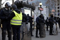 Một người biểu tình Áo vàng đứng trước chốt chặn của cảnh sát, ngày 8/12. (Nguồn: AFP)