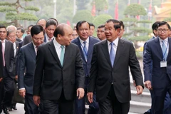Thủ tướng Nguyễn Xuân Phúc trao đổi thân mật với Thủ tướng Campuchia Samdech Techo Hun Sen trên đường đến Trụ sở Chính phủ để hội đàm. (Ảnh: Văn Điệp/TTXVN)