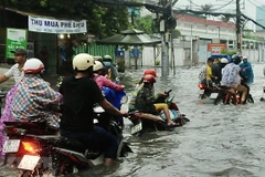 Đường Tân Hòa Đông (quận Bình Tân) bị ngập sâu do mưa lớn kết hợp triều cường. (Ảnh: Hồng Giang/TTXVN)
