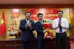 Tân Phó Bí thư Tỉnh uỷ, Chủ tịch UBND tỉnh Cà Mau Lê Quân nhận hoa chúc mừng từ Bí thư Tỉnh ủy Nguyễn Tiến Hải và Chủ tịch HĐND tỉnh Trần Văn Hiện. (Ảnh: Kim Há/TTXVN)