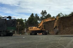 Xe múc khai thác đất đá trái phép tại hiện trường. (Ảnh: Phạm Cường/TTXVN)