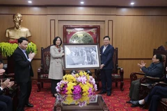 Tổng giám đốc TTXVN Vũ Việt Trang tặng tỉnh Bắc Kạn bức ảnh Chủ tịch Hồ Chí Minh thăm nông dân Bắc Kạn (1950). (Ảnh: Vũ Hoàng Giang/TTXVN)