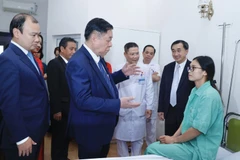 Trưởng Ban Tuyên giáo Trung ương Nguyễn Trọng Nghĩa thăm hỏi, tặng quà cho bệnh nhân đang điều trị tại Bệnh viện Thể thao Việt Nam. (Ảnh: Minh Quyết/TTXVN)