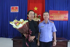 Đại diện Viện Kiểm sát nhân dân thành phố Nha Trang tặng hoa cho ông Thái Xuân Đàn trong buổi xin lỗi sáng 24/12. (Ảnh: Nguyễn Dũng/TTXVN)