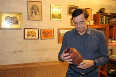 Anh Zhenya xem những kỷ vật gắn liền với đất nước Việt Nam. (Ảnh do nhân vật cung cấp/Vietnam+)