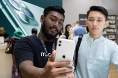 Nhân viên Apple ở Kuala Lumpur giới thiệu cho khách hàng về mẫu điện thoại iPhone 11. (Nguồn: Getty Images)