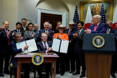 Đại sứ Nhật Bản Shinsuke Sugiyama và Đại diện Thương mại Mỹ Robert Lighthizer giơ Hiệp định Thương mại Mỹ-Nhật Bản bên cạnh Tổng thống Donald Trump và đại biểu hai nước, trong lễ ký tại Nhà Trắng. (Nguồn: Reuters) 