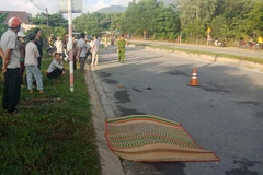 Công an huyện Đức Phổ khám nghiệm hiện trường vụ tai nạn. (Ảnh: Phước Ngọc/TTXVN)