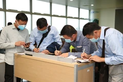 Nhân viên y tế kiểm tra phiếu khai báo y tế của hành khách trước khi làm thủ tục nhập cảnh tại cửa khẩu Sân bay quốc tế Nội Bài (Hà Nội), chiều 7/3. (Ảnh: Dương Giang/TTXVN)