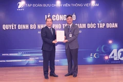 Ông Phạm Đức Long trao quyết định Phó Tổng Giám đốc cho ông Nguyễn Nam Long (phải). (Ảnh: CTV/Vietnam+)