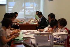 Các cán bộ Ban Đấu giá HNX đang kiểm tra hòm phiếu. (Ảnh: Doãn Đức/Vietnam+)