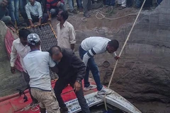 Xe bus lao xuống giếng.