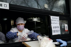Cửa hàng bánh bao dùng ván gỗ đưa hàng cho khách. (Ảnh: Reuters)