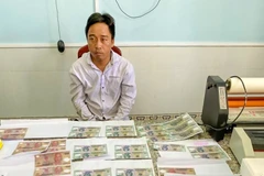 Đối tượng T. cùng tang vật. (Ảnh: TTXVN phát)