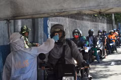 Kiểm tra thân nhiệt cho lái xe tại Manila. (Ảnh: AFP/TTXVN)