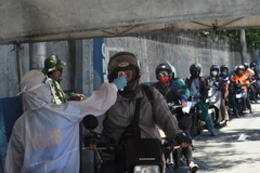 Kiểm tra thân nhiệt cho lái xe tại Manila. (Ảnh: AFP/TTXVN)